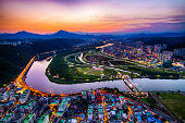 An aerial shot of cityscape and a beautiful river at sunset in Ulsan,...